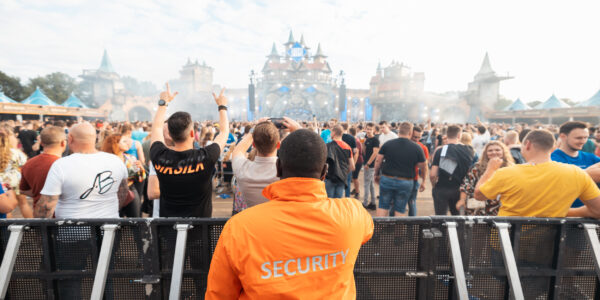 Evenementenbeveiliger kijkt uit over de bezoekers en het podium op een festival