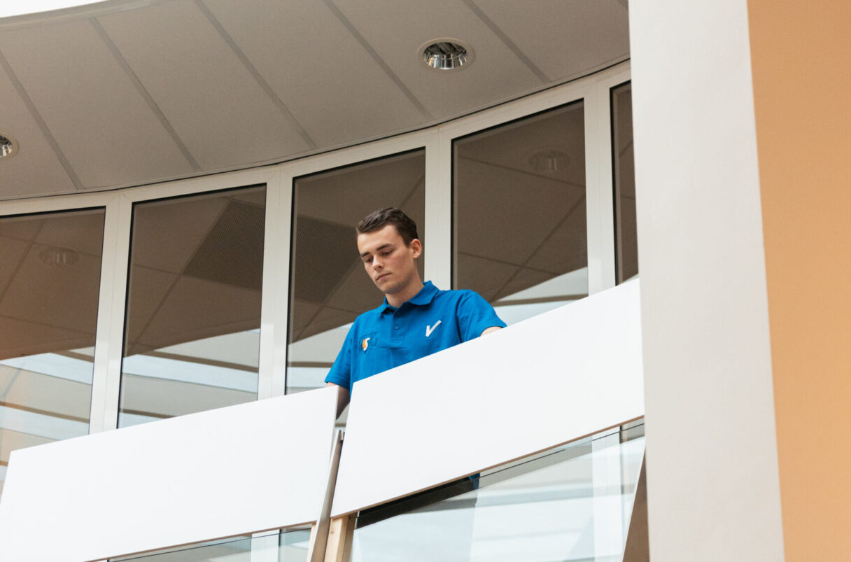 Objectbeveiliger kijkt vanaf een balkon door het gebouw
